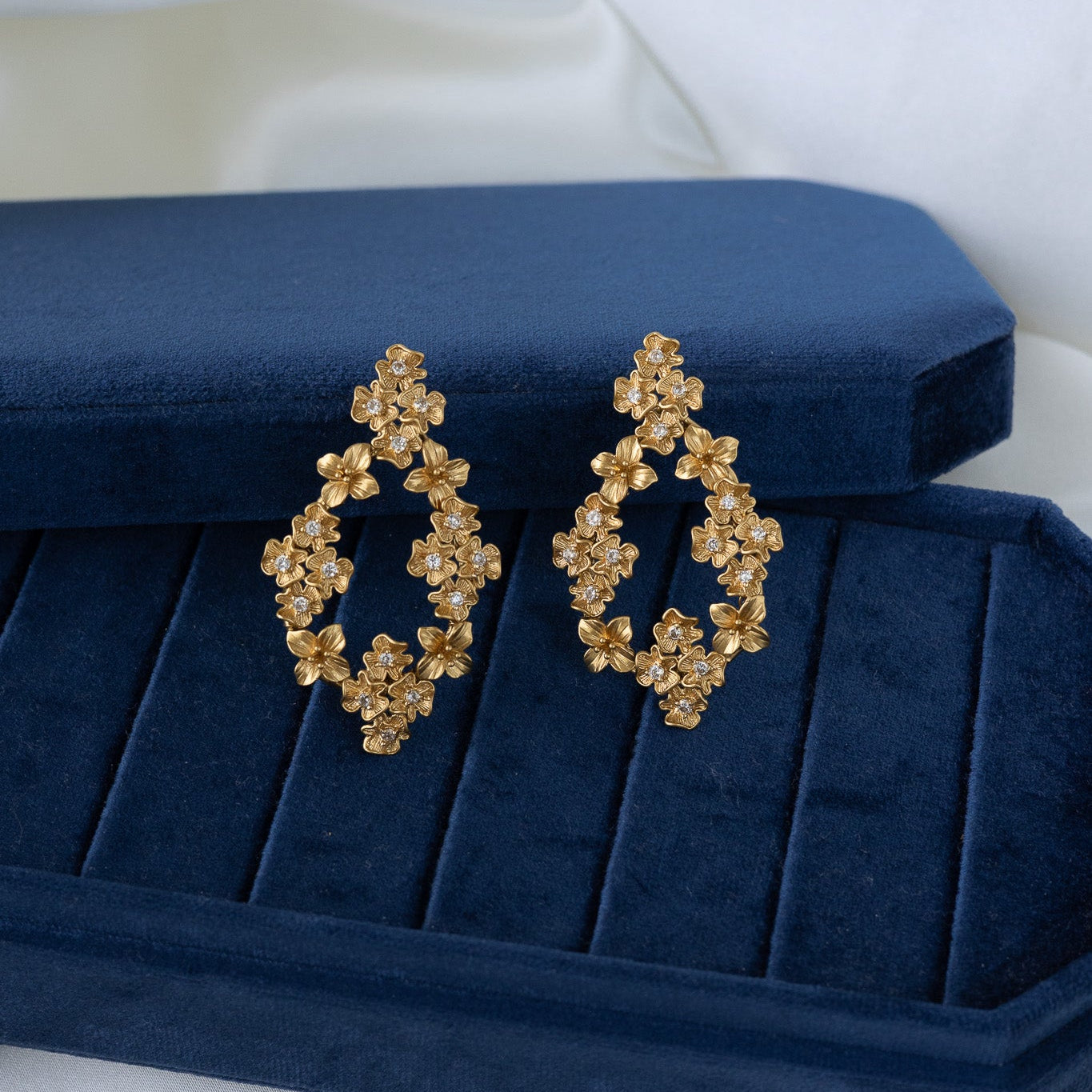 blossom bold earrings on velvet blue box