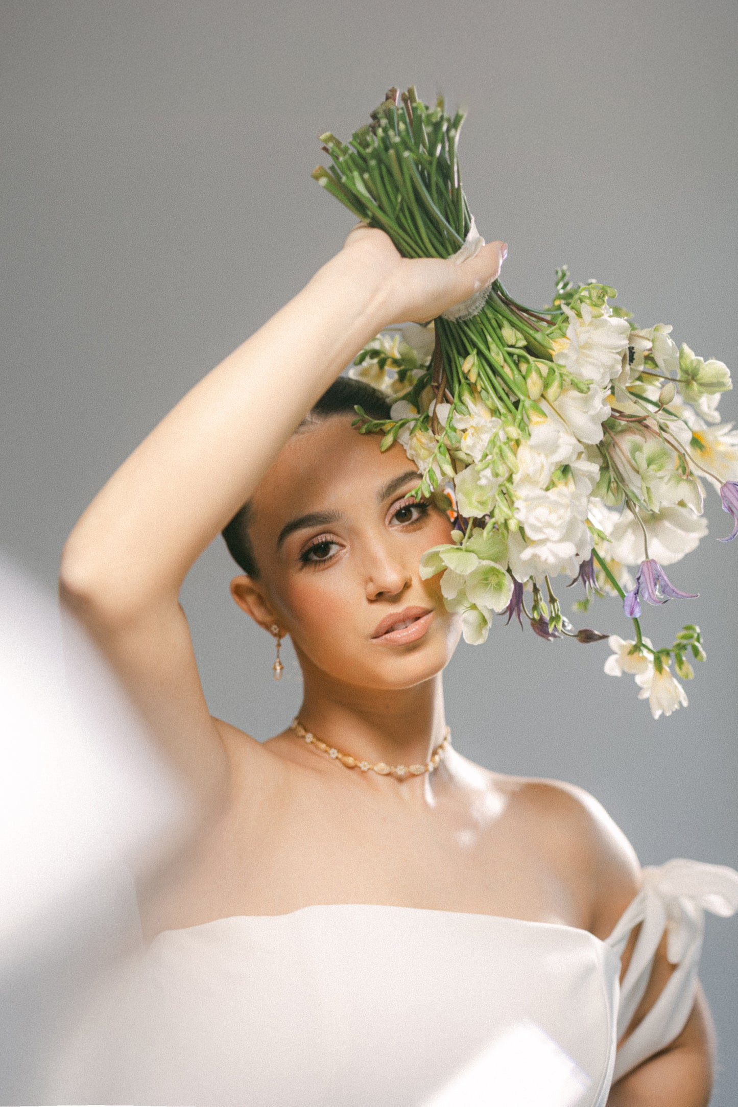 Woman holding a bouquet of flowers against a gray background