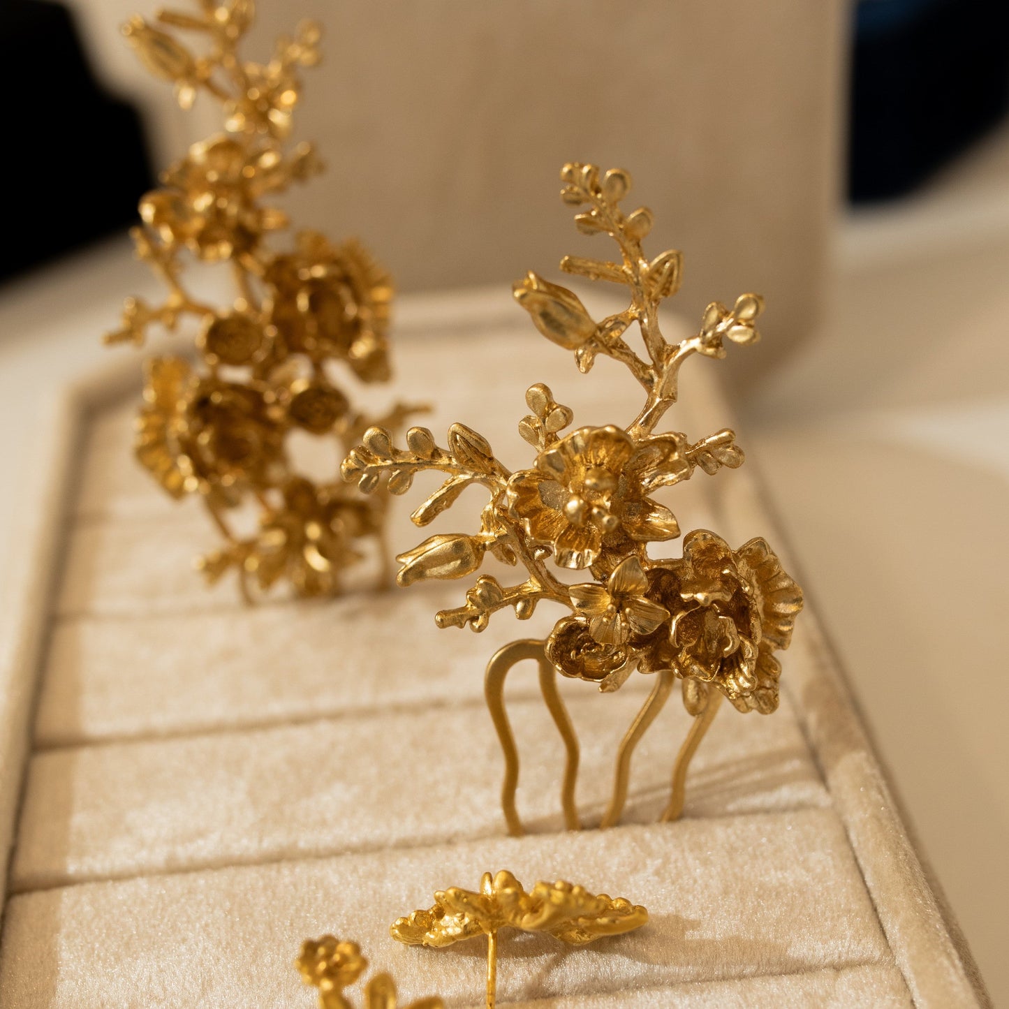 Gold floral hairpins on a beige jewelry display box