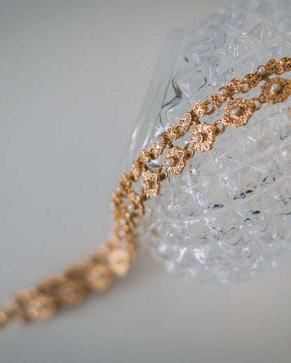 Gold  necklace on a clear crystal object with a neutral background