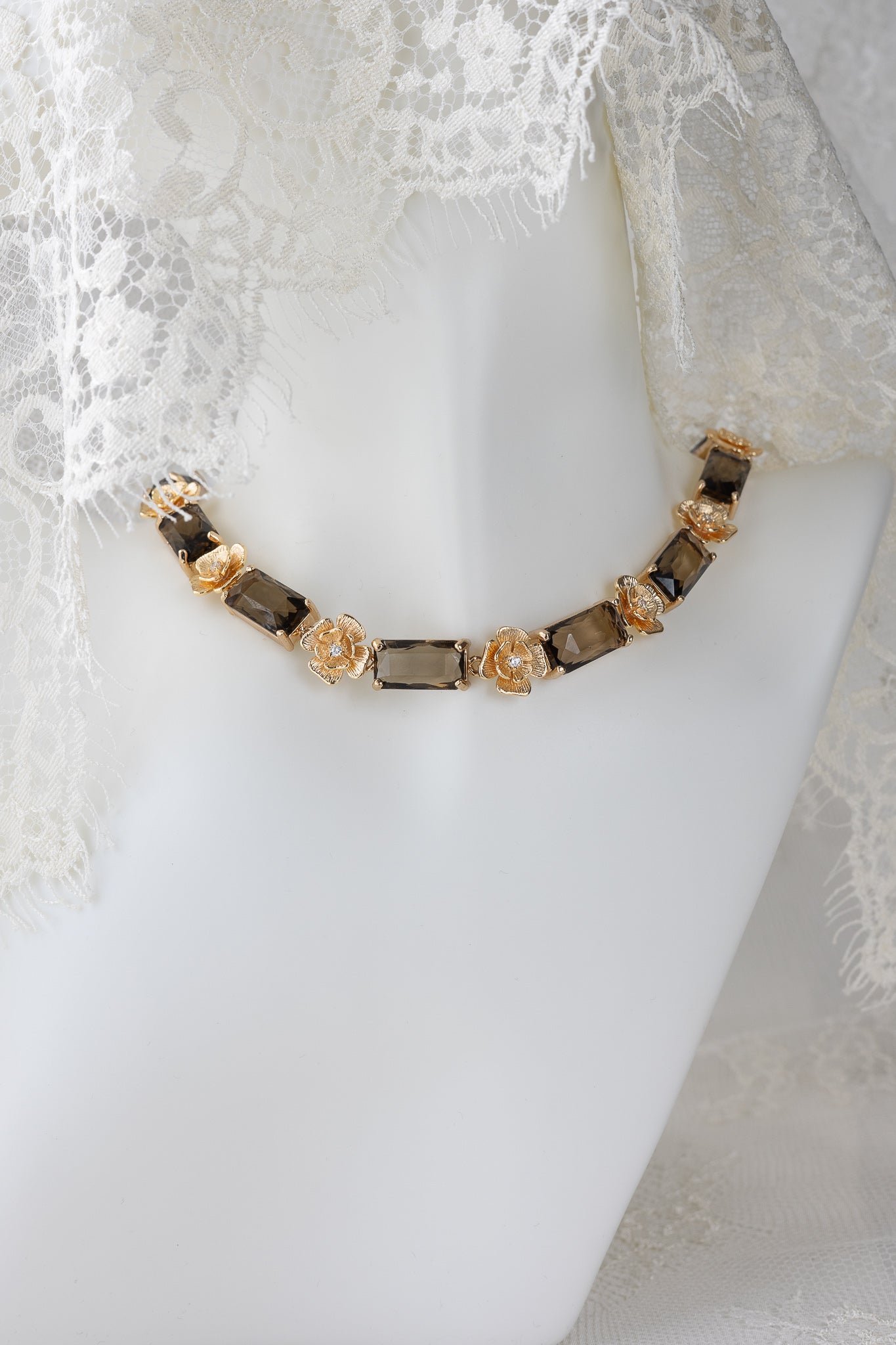 Necklace with golden flowers and brown stones on a mannequin with lace veil