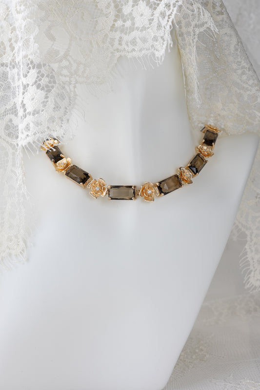 Necklace with golden flowers and brown stones on a mannequin with lace veil